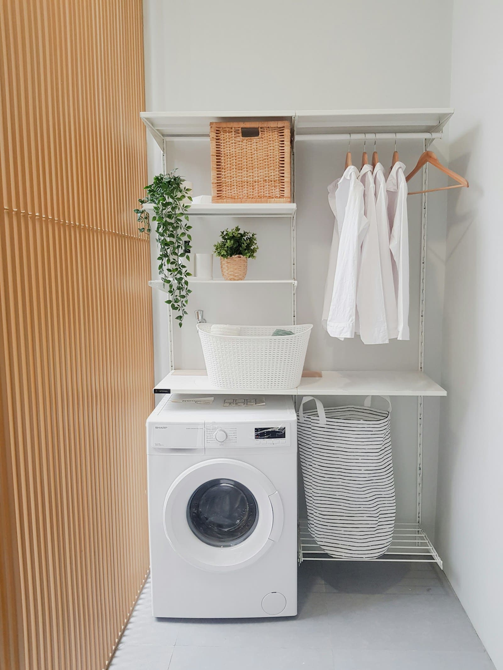 Buanderie lumineuse avec un lave-linge et du linge suspendu
